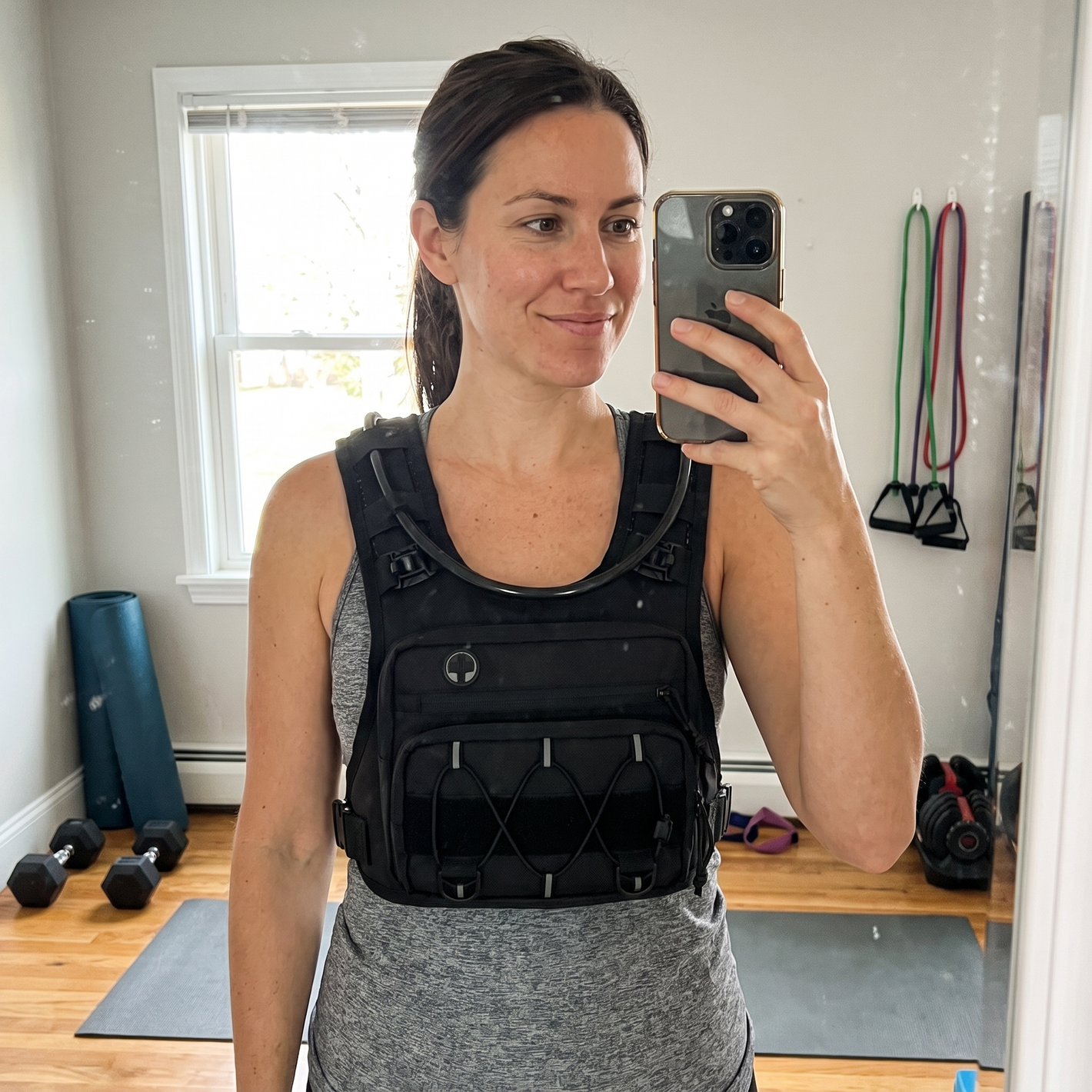 Woman wearing HydraKor hydration vest in home gym mirror selfie